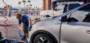 Cobblestone team member uses microfiber towel to hand dry a car after a car wash|Cobblestone_Full_Service_Car_Wash_Vacuuming