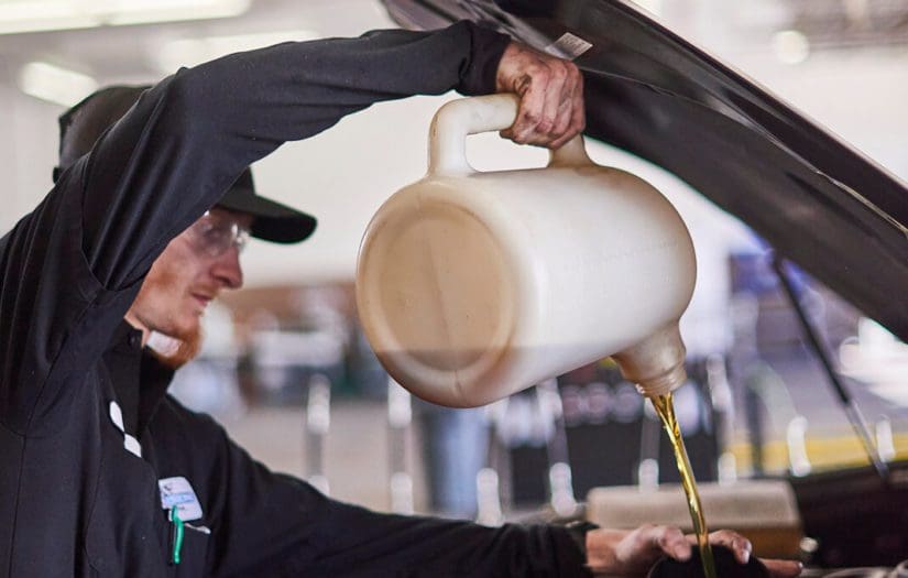 Cobblestone technician lifts hood of car for an oil change||