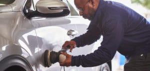 Technician applies ceramic coating to car exterior to restore exterior luster.|Exterior car detailing cleans a truck's headlights to restore clarity and shine.|