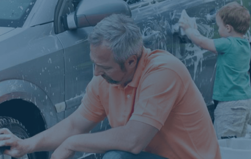 Man and his son handwashing a car.