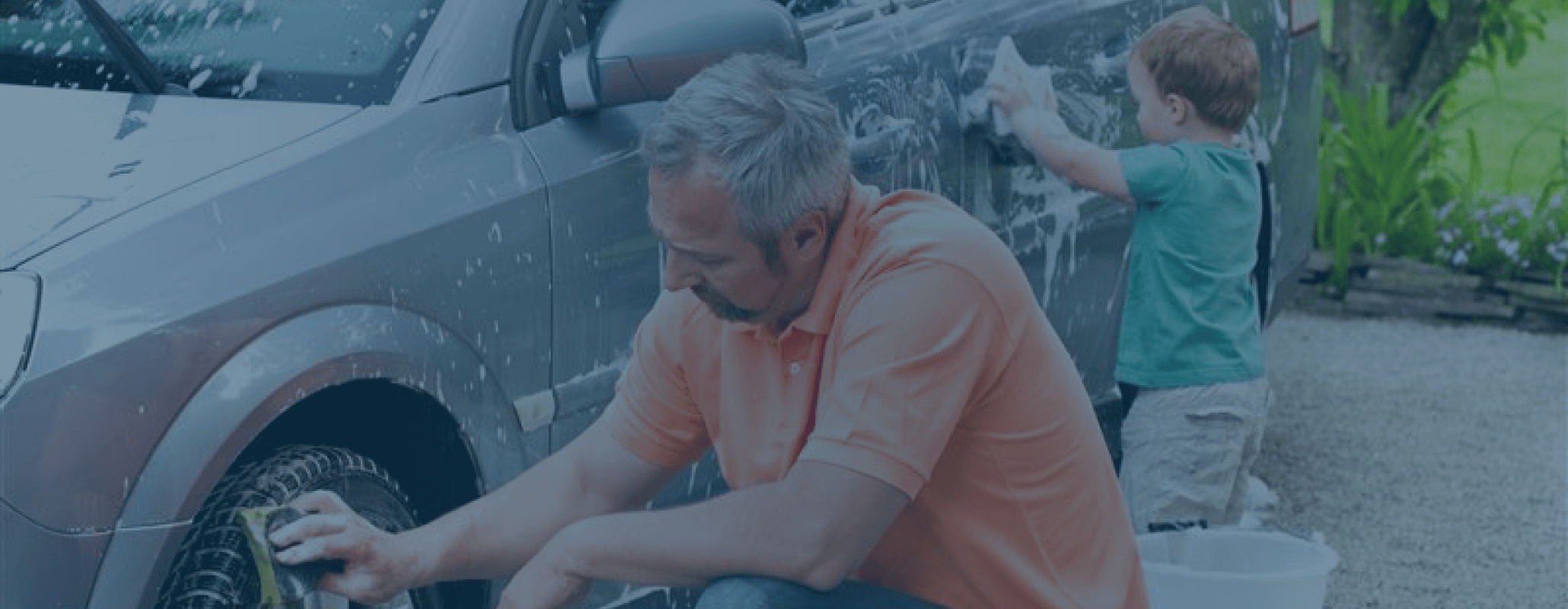 Man and his son handwashing a car.